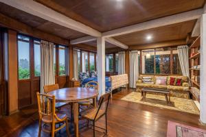 a living room with a table and chairs and a couch at The Fern Lodge in Bedugul