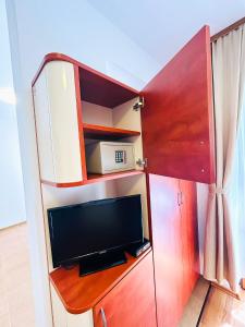 ein Wohnzimmer mit einem TV und einem Schrank mit einem TV und einem TV. in der Unterkunft Family Hotel Helios in Sonnenstrand