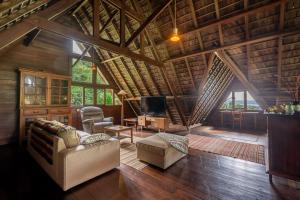 a living room with a couch and chairs in a cabin at The Fern Lodge in Bedugul