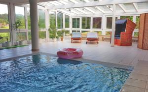 a swimming pool in a house with a conservatory at Haus am Osterbrünnl in Ruhmannsfelden