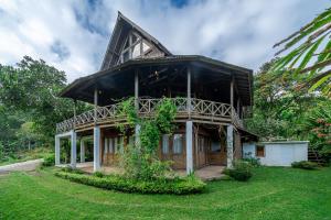 a house with a large roof on a green yard at The Fern Lodge in Bedugul