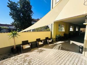 a group of chairs and a building with a tent at Neva Apartments & Rooms in Făgăraş