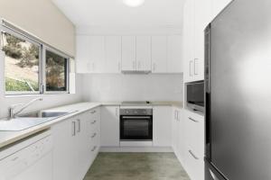 スレッドボにあるボバック 3Bのシンクと冷蔵庫を備えた白いキッチン +8枚の写真