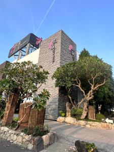 un bâtiment avec des arbres devant lui dans l'établissement Orient Luxury Villa Motel, à Huwei