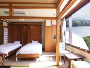 two beds on the balcony of a boat at Hotel Koryu in Fujikawaguchiko