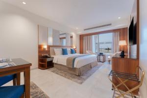 ein Hotelzimmer mit Bett und Schreibtisch in der Unterkunft Corp Yanbu Hotel - B1 in Yanbu