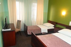 a hotel room with two beds and a television at Motel Atlantis in Prijedor
