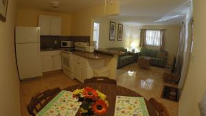 a kitchen and living room with a table with flowers on it at Lago Mar Motel and Apartments in Lake Worth