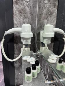 a bathroom with a mirror with two hair driers and a hair dryer at HİSAR HOTEL in Istanbul