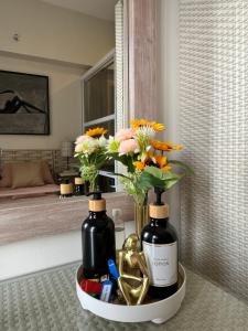Dos botellas de vino y flores en un estante en un baño. en RRS Cabin, Primeworld District, en Lapu Lapu City 12 fotos más