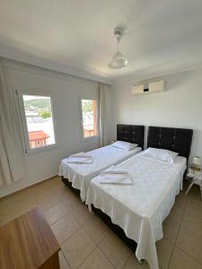 - 2 lits dans une chambre avec 2 fenêtres dans l'établissement Pinky Apart Otel Bodrum, à Bodrum City