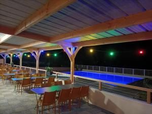 a patio with tables and chairs and a swimming pool at Camping L'oasis Du Berry - chalets climatisés in Saint-Gaultier