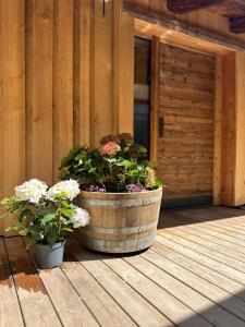 two potted flowers in a barrel on a porch at Peer Alm in Navis