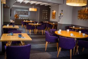 a restaurant with wooden tables and purple chairs at Logis Hostellerie de l'Abbaye in Celles-sur-Belle