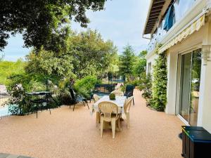 un patio avec une table et des chaises et un plan de travail table et chaises dans l'établissement Villa Les Ruches - Piscine & Clim, à Bras