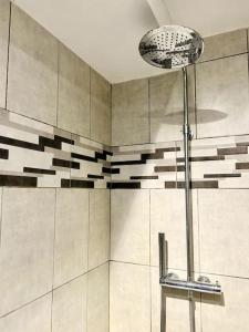 La salle de bains est pourvue d'une douche et d'une lampe. dans l'établissement Villa Les Ruches - Piscine & Clim, à Bras