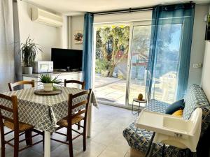 d'un salon avec une table, des chaises et une porte coulissante en verre. dans l'établissement Villa Les Ruches - Piscine & Clim, à Bras