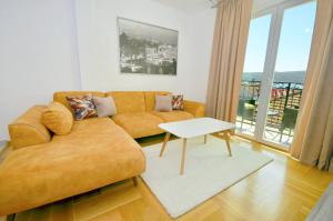 a living room with a couch and a table at Discovery Point Apartments in Tivat