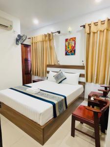 um quarto com uma cama grande e uma mesa em DINH DINH 2 AIRPORT HOTEL em Cidade de Ho Chi Minh