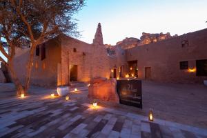 un edificio con luces en medio de un patio en Dar Tantora The House Hotel, en Al Ula