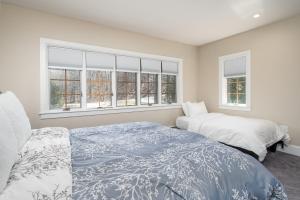a bedroom with two beds and two windows at Bearet - Hot Tub, Grill, Game Room, Fireplace in Killington
