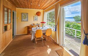 a dining room with a table and chairs and a large window at Nice Home In Klokkarstua With Wifi in Ustad