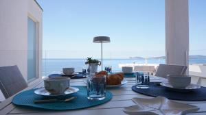 a dining table with a view of the ocean at Postcard in Alghero