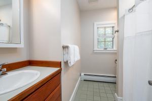 a white bathroom with a sink and a window at Bearet - Hot Tub, Grill, Game Room, Fireplace in Killington +43 photos