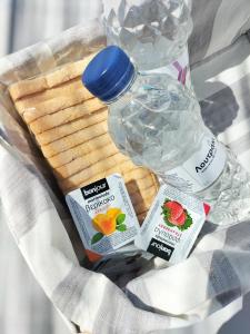 un cestino pieno di cracker, una bottiglia d'acqua e una ciotola di ghiaccio di Angelina Greek House a Paroikia