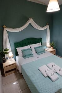1 dormitorio con 1 cama con cabecero verde y almohadas en Eolos Villa, en Parga