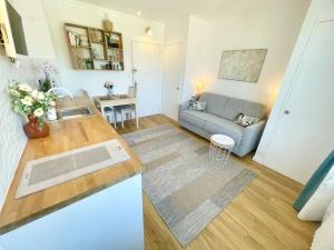 a kitchen and living room with a couch and a table at Confortable studio à 2min de la plage et du centre in Cabourg +2 photos