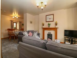 a living room with two couches and a fireplace at Ty Pili Pala in Betws-y-coed