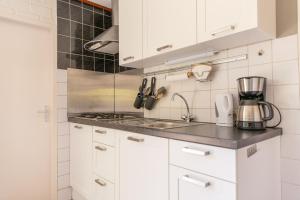 Sint Maartensvlotbrug的住宿－Kloosterbos 5，厨房配有白色橱柜和台面