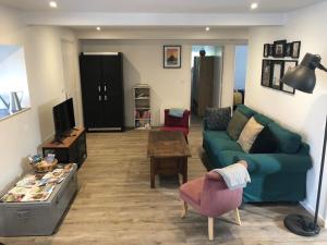 CouvainsGîte de l'hôtel Castel的客厅里有一张绿色的沙发和一张桌子