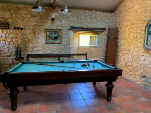 a pool table in a room with a stone wall at Château de Monsac in Monsac