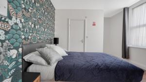 巴尔金Comfy Double En-suite room in Barking的卧室里有一张床，床铺是蓝色的