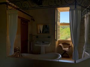 a bathroom with a tub and a sink and a window at Château de Monsac in Monsac
