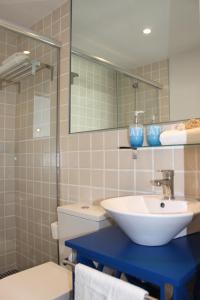 a bathroom with a sink and a toilet and a mirror at Corralejo Lodge in Corralejo