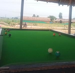 a green pool table with balls on it at Nirvana Hampi in Hampi