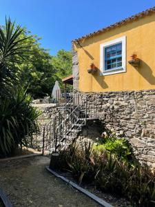 a house with a stone staircase next to a window at Moinho do Granjão - Water Mill in Mesão Frio +35 photos