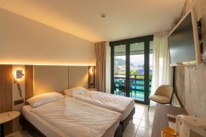 Postel nebo postele na pokoji v ubytování Hotel Tiziana + 30 fotografií