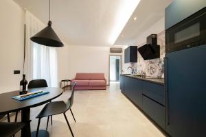 a kitchen and living room with a pink couch at ApartmentsGarda - Residenza Garda Deluxe in Garda
