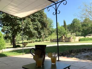 a table with a cup and two drinks on it at Château de Monsac in Monsac