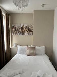 黑潭的住宿－New Derina Hotel，卧室配有一张带吊灯的大型白色床。