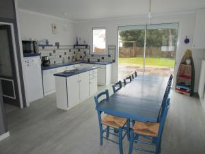 eine Küche mit einem blauen Tisch und Stühlen darin in der Unterkunft Maison 6 pers - 3ch à Saint Hilaire de riez classé 3 Etoiles in Saint-Hilaire-de-Riez + 2 Fotos