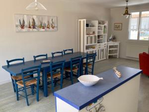 ein Esszimmer mit einem blauen Tisch und Stühlen in der Unterkunft Maison 6 pers - 3ch à Saint Hilaire de riez classé 3 Etoiles in Saint-Hilaire-de-Riez