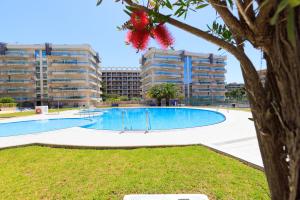an empty swimming pool with apartment buildings in the background at UHC Larimar Family Complex in Salou