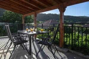 a table and two chairs on a balcony with a view at Manolis Stone House Villa in Mouríon