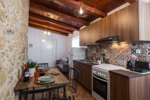 a kitchen with a table and a counter top at Manolis Stone House Villa in Mouríon