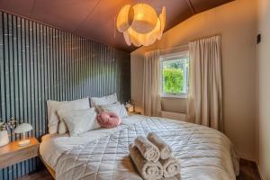 a bedroom with a large bed with towels on it at Hotel chique tiny wellness hottub & sauna in Voorthuizen